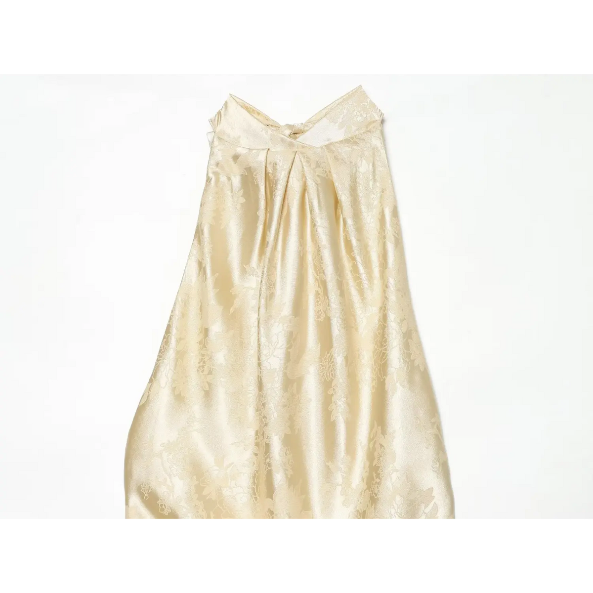 Close-up of gathered halter neckline on champagne jacquard dress