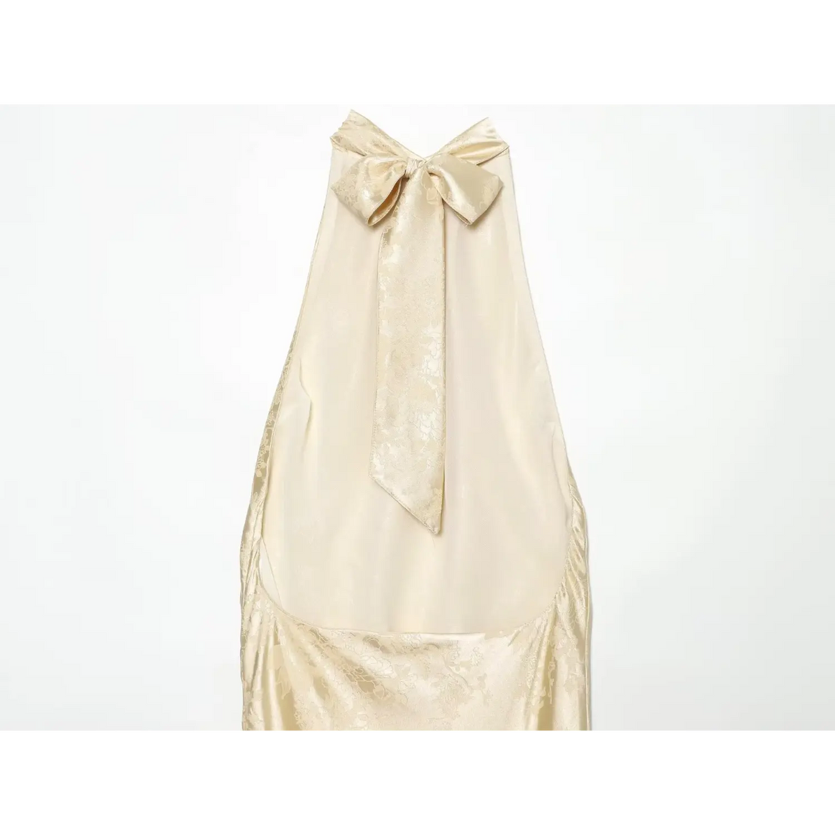 Close-up of open back and bow tie on champagne halter dress