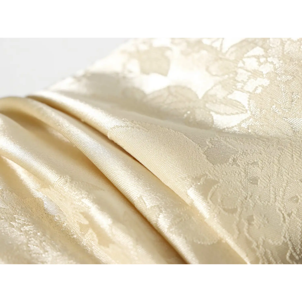 Close-up of lustrous champagne satin jacquard fabric folds