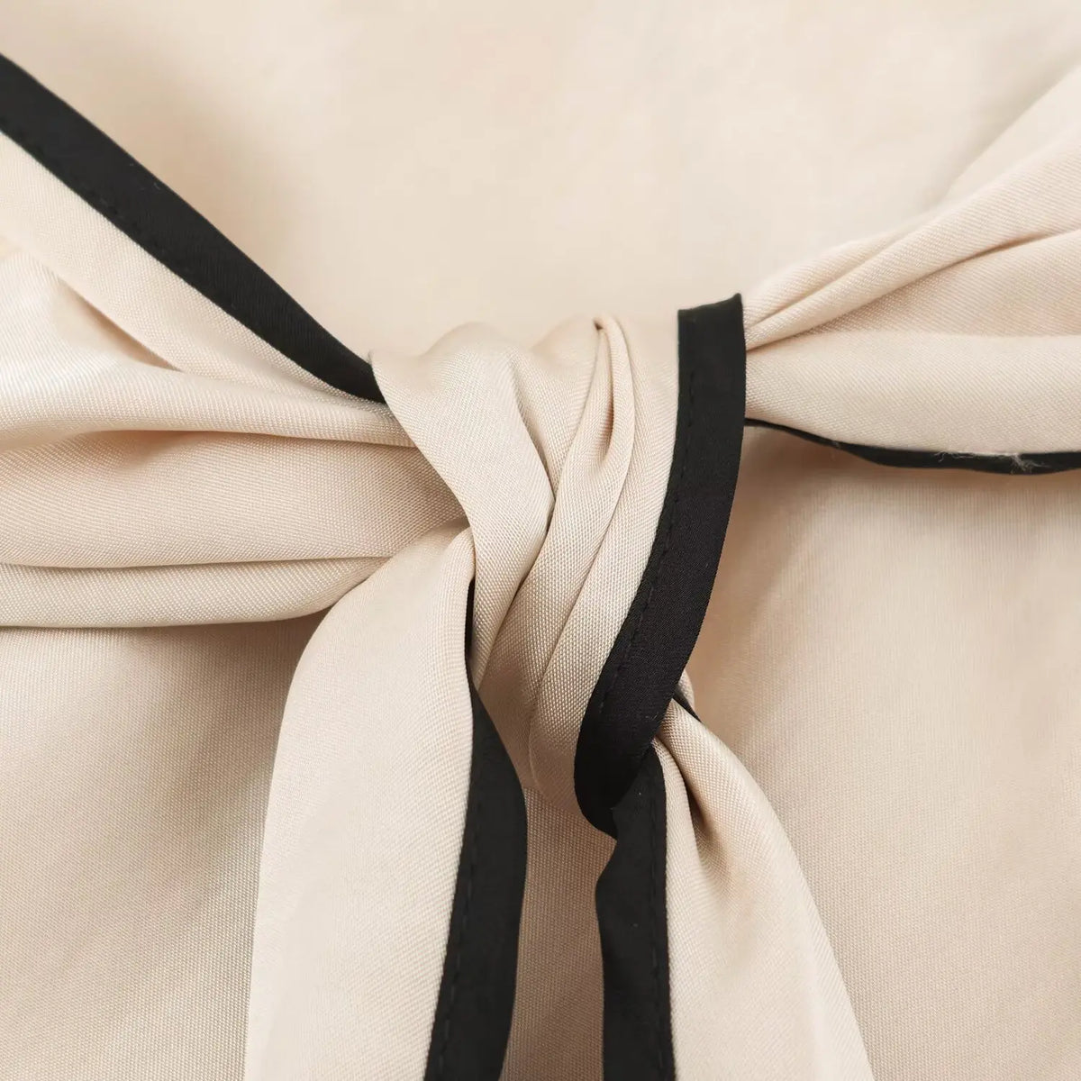 Close-up of tie knot with black binding
