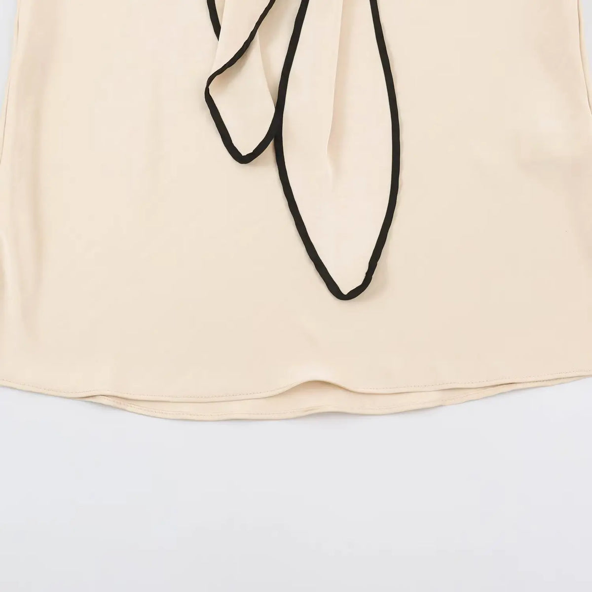 Close-up of hanging tie ends and skirt hem