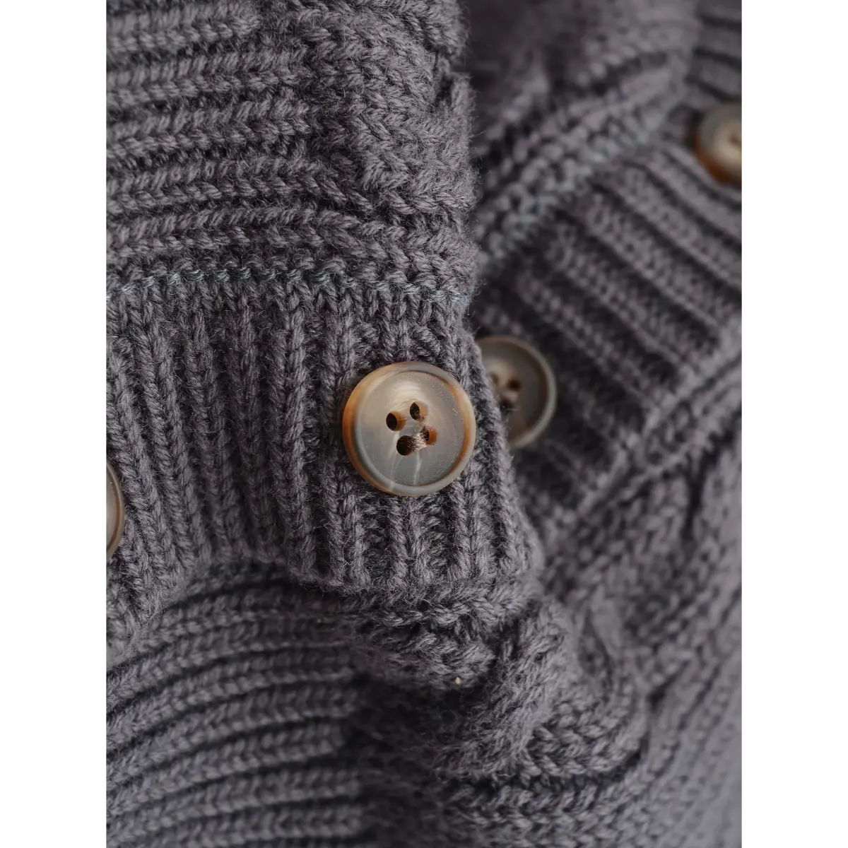 Close-up of the marbled brown buttons and detailed knit texture on the cardigan.