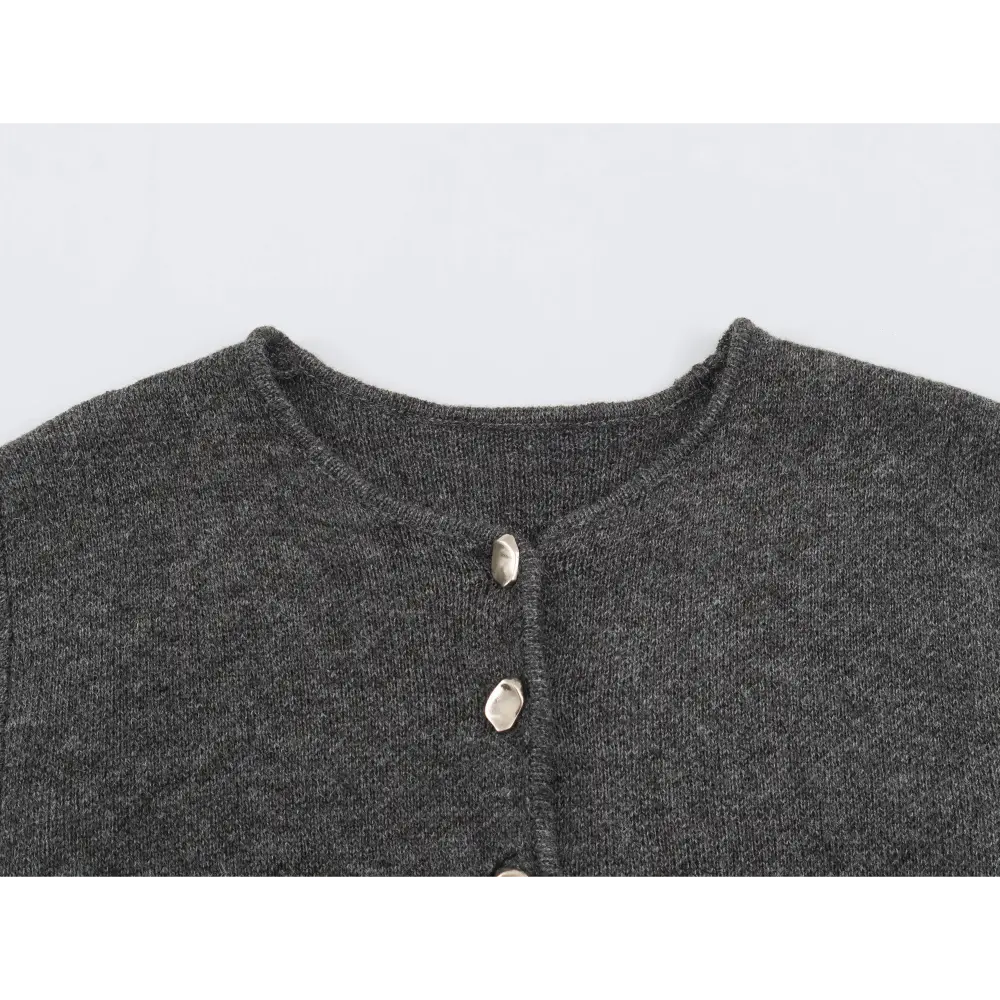 Close-up of round neckline and irregular metal buttons