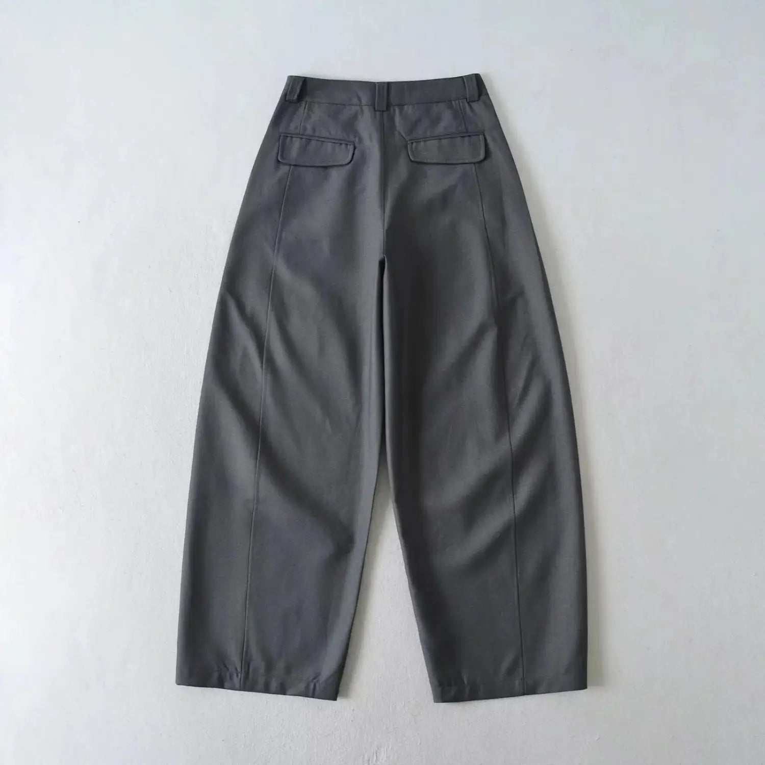 Back view flat lay of charcoal gray wide leg dress pants, highlight double back patch pockets and side seams