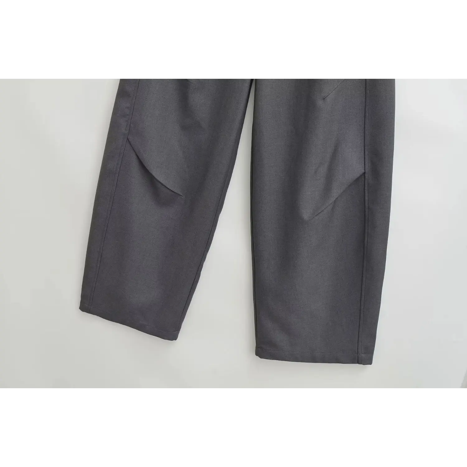 Close-up shot of charcoal gray wide leg trousers leg section, show folded hem, seam stitching and soft drape fabric texture