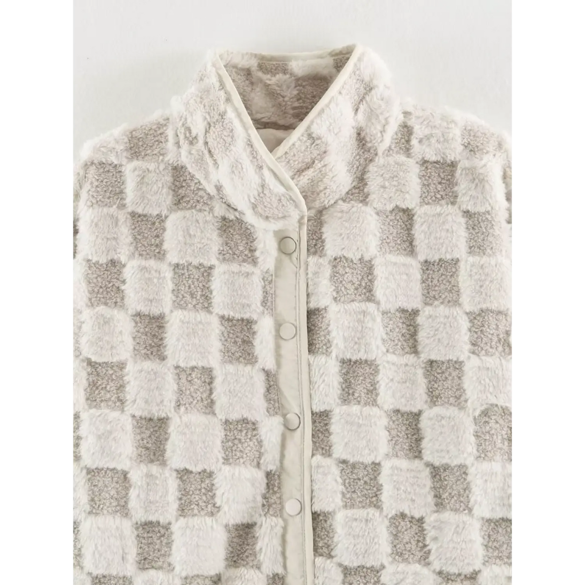 Close up of stand collar and button placket on beige white checkered faux fur women jacket