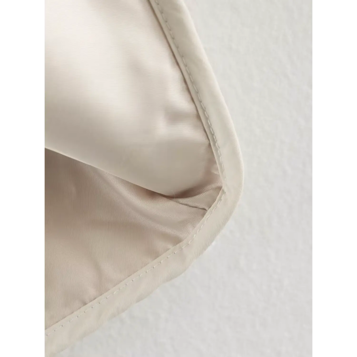 Close view of smooth beige inner lining and hem stitching of women checkered sherpa jacket