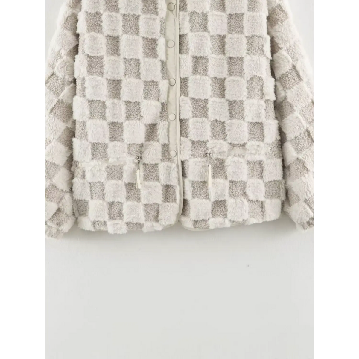 Close view of zipper pocket and front buttons on women checkered fuzzy fur coat