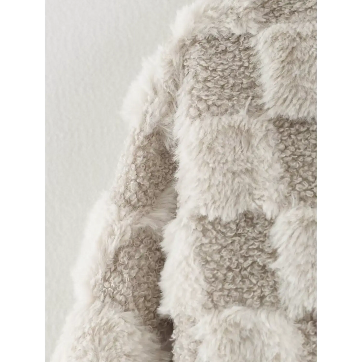 Side closeup showing dual textured checkerboard fabric of women warm fur jacket