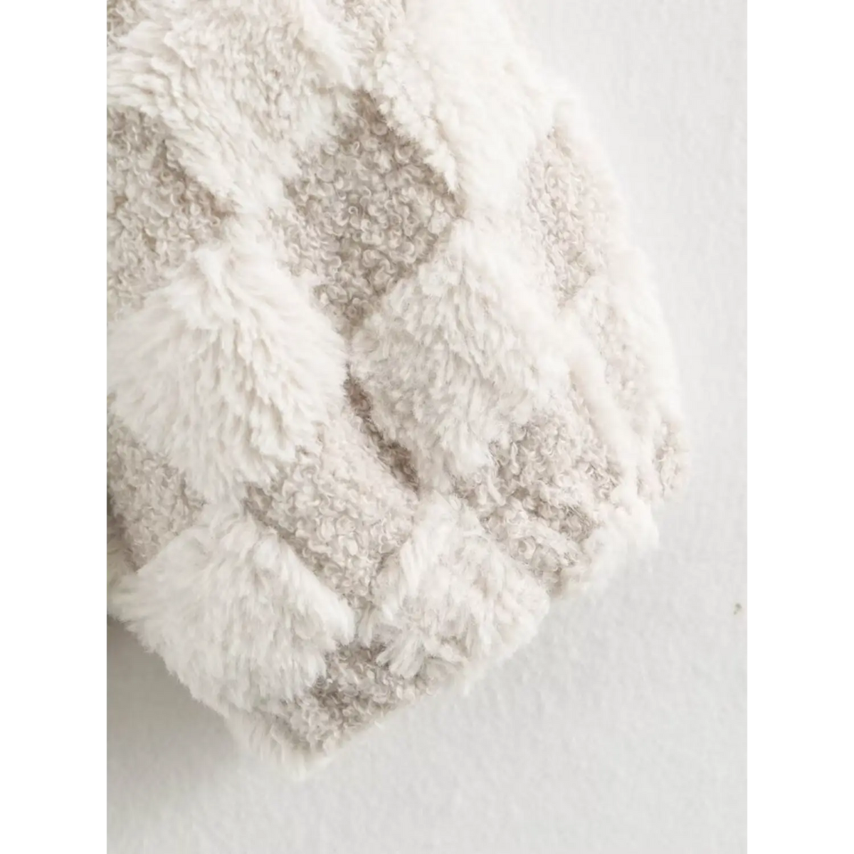 Closeup of sleeve cuff and checkerboard fuzzy fabric texture on women winter jacket