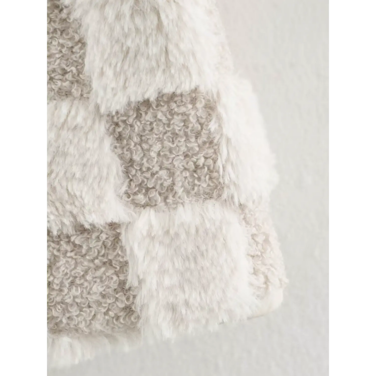 Close-up of sleeve fabric, dual texture curly sherpa and soft faux fur checkered pattern for women winter coat