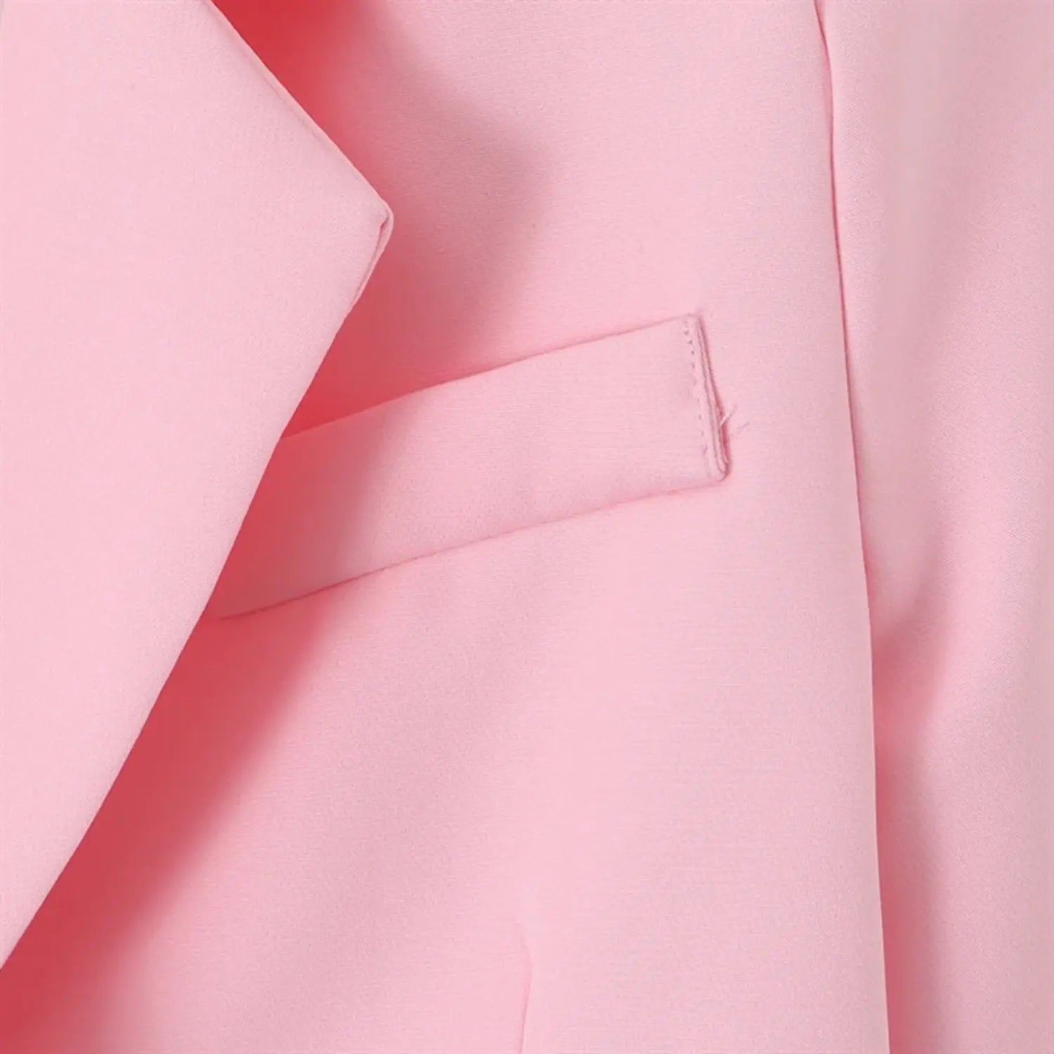 Chest pocket close-up, small flap pocket, clean edge stitching, pink woven suiting fabric texture