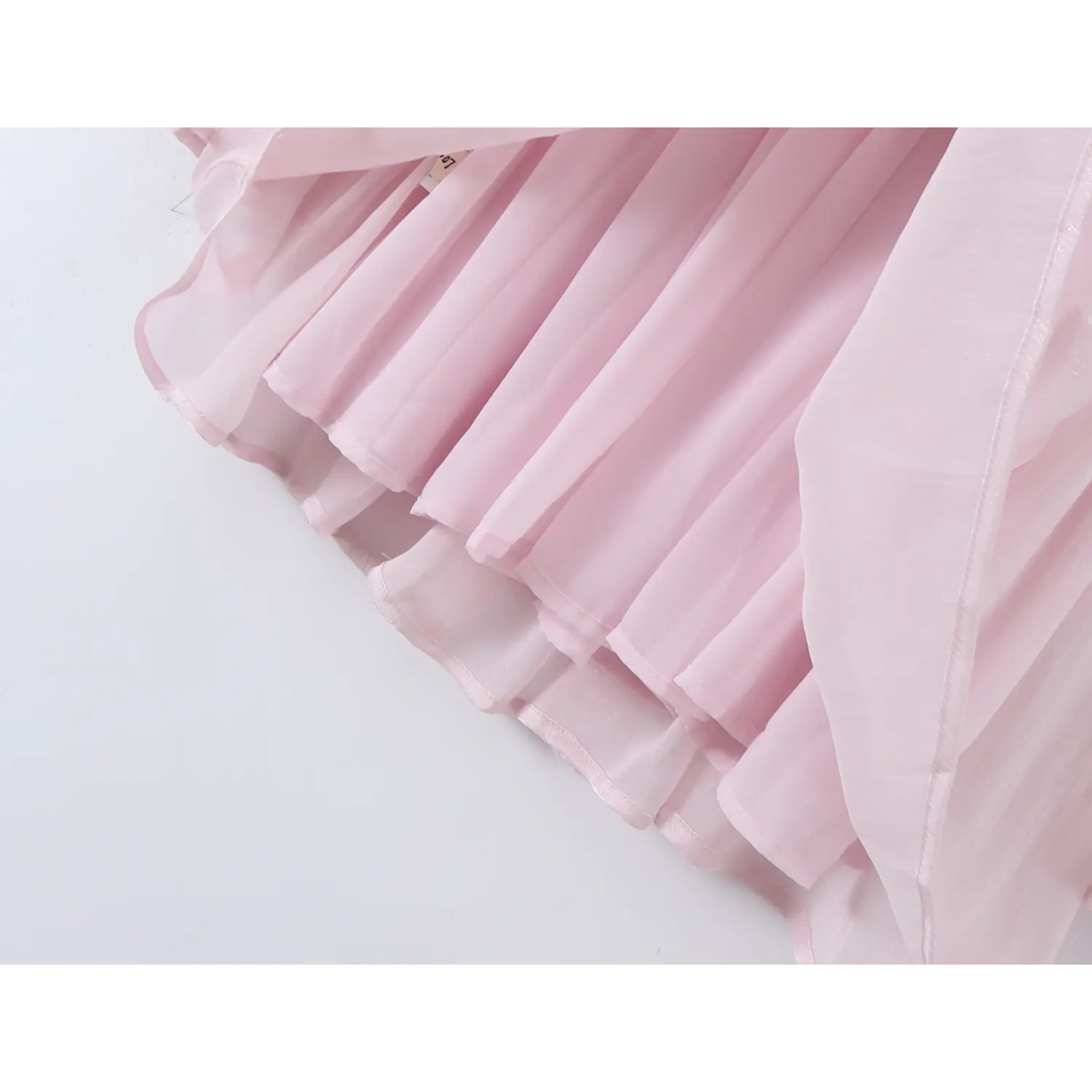 Skirt hem close-up, layered gathered chiffon, soft flowy folds, uneven airy hem, pale pink sheer fabric drape