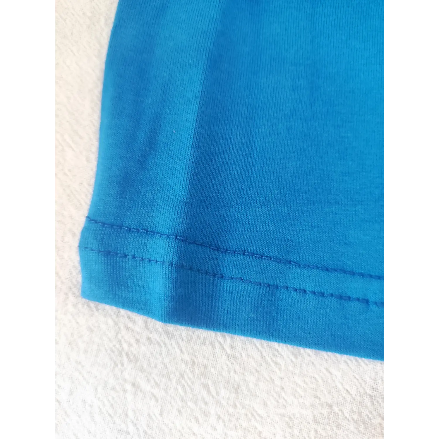 Macro shot neat hem stitching detail stretch blue cropped short sleeve t-shirt