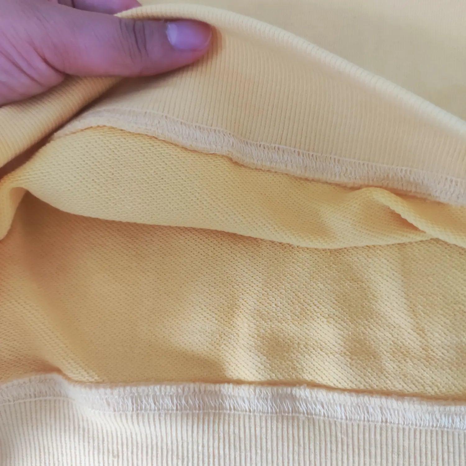 Close-up inside terry knit fabric texture yellow casual long sleeve sweatshirt