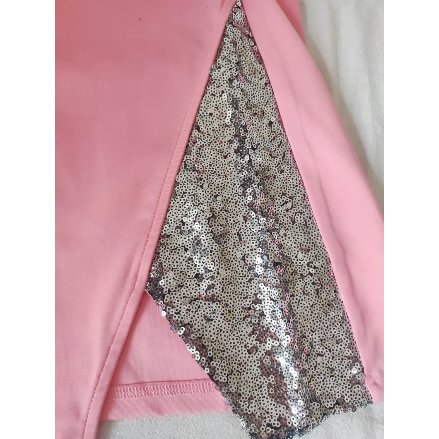 Macro close-up silver shiny sequin fabric panel on side split of pink stretch bodycon dress