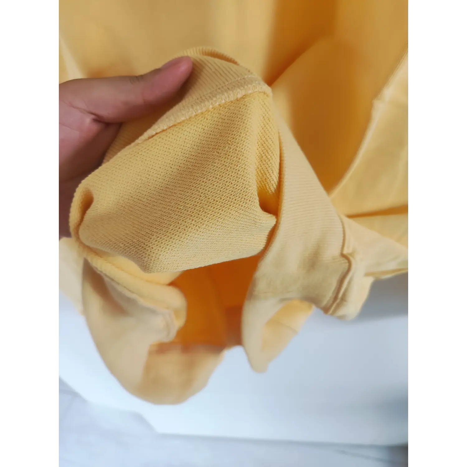 Close-up terry fabric texture of ribbed sleeve cuff yellow sweatshirt