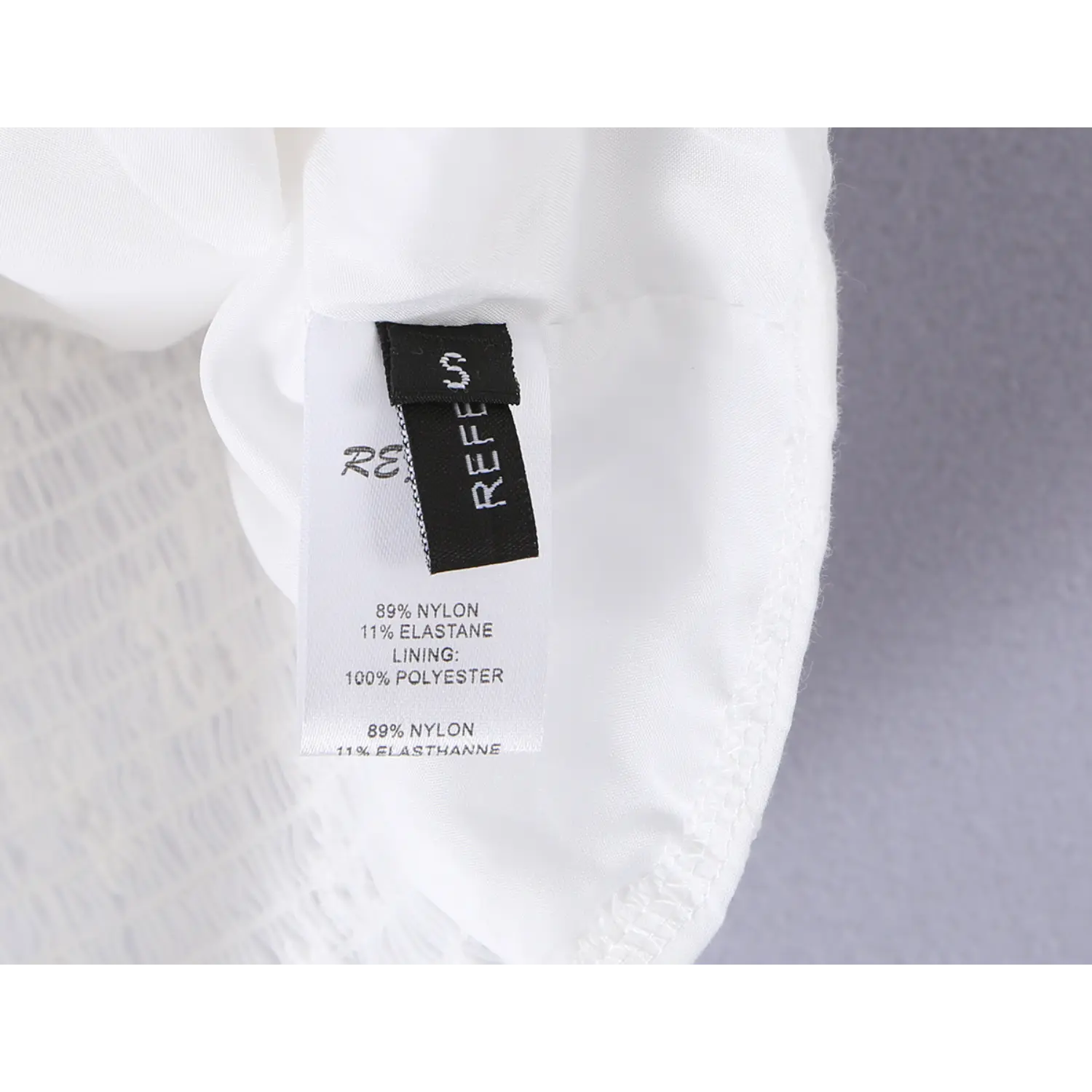 Close-up of garment size S and laundry care symbols on the fabric label