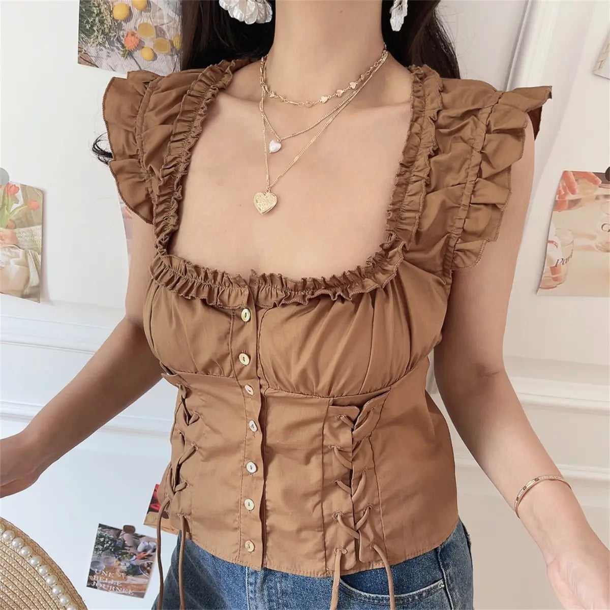 Front lifestyle shot wearing brown ruffle corset crop top with denim shorts and straw hat, retro casual look.