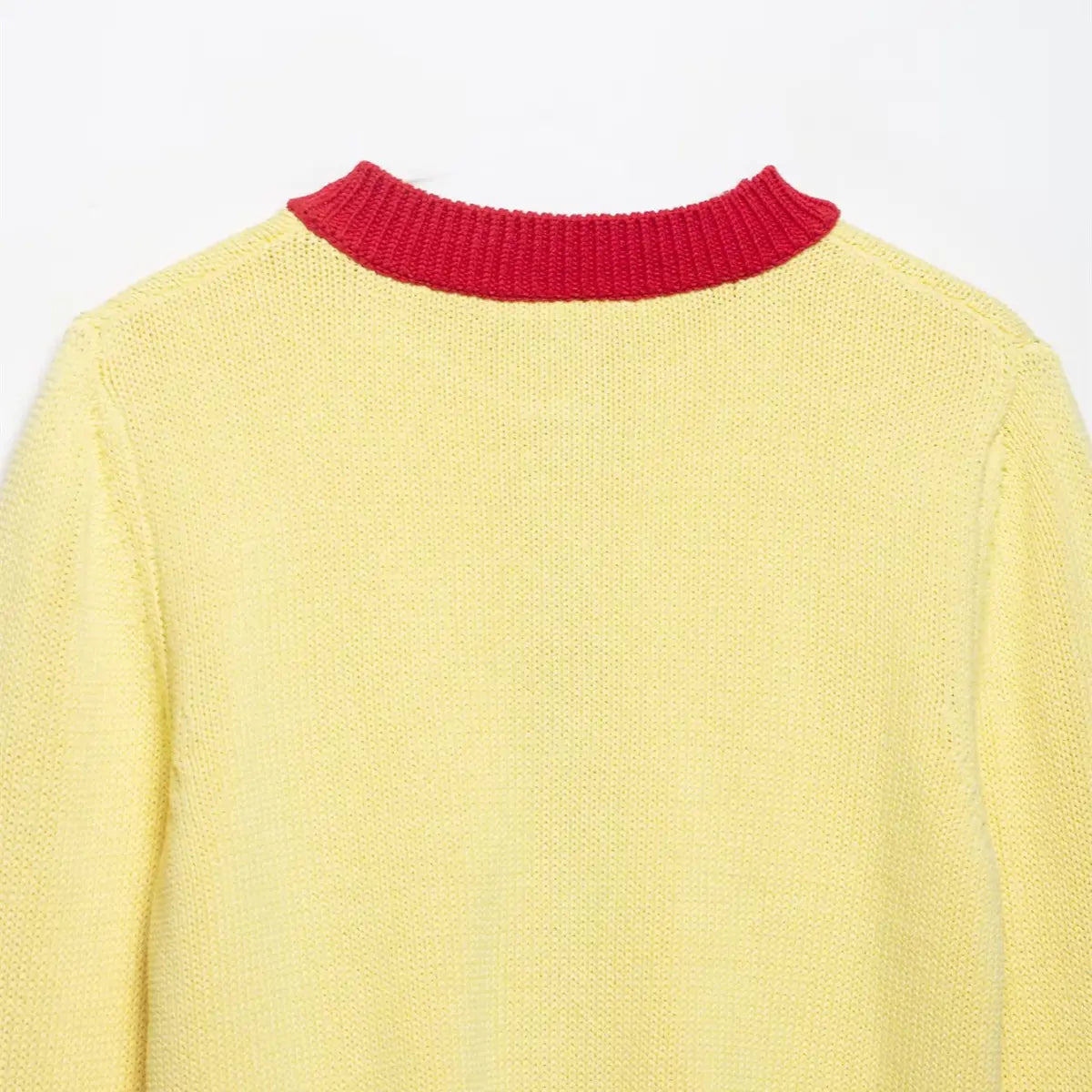 Close-up of the back neckline on the color-block knit cardigan, showing the red ribbed collar and solid yellow body
