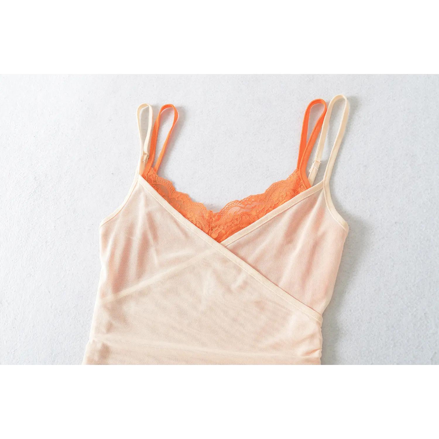 Color block lace lined mesh cami front hanger close-up flat lay, V neck orange floral lace wrap cross outer mesh side ruched waist fit white background shot