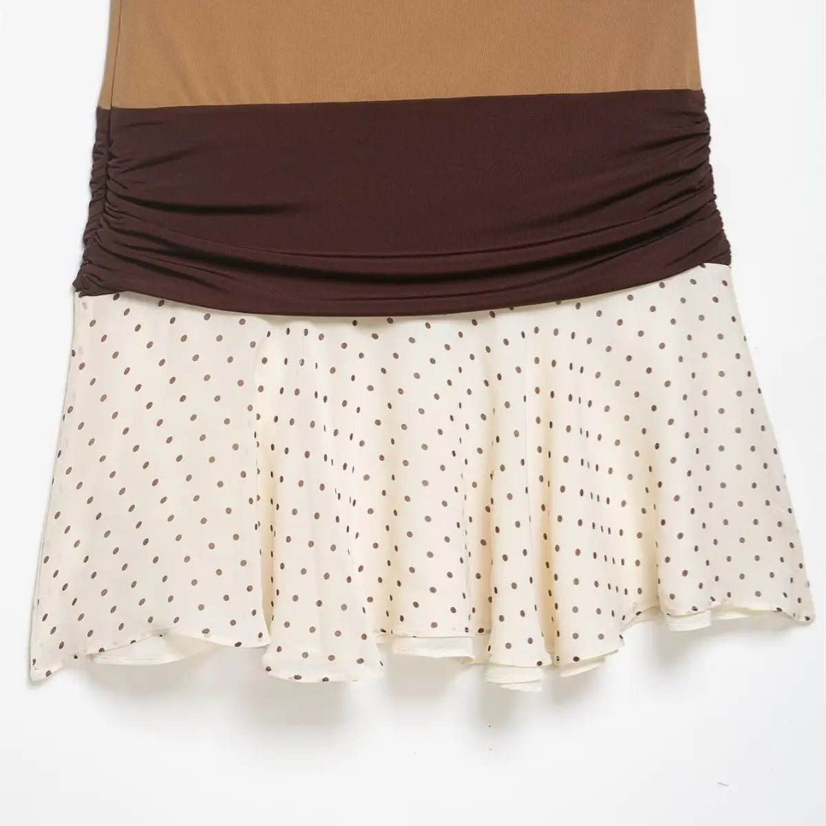 Close-up of the skirt on the colorblock dress, showing the cream base with brown polka dots and flowy layered hem