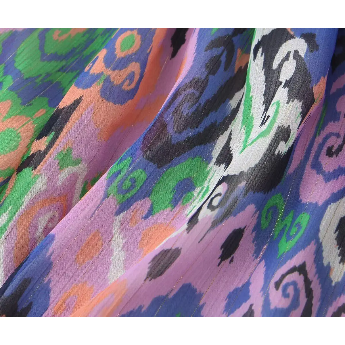 Wide detail shot of the vibrant ikat pattern on the lightweight dress fabric.