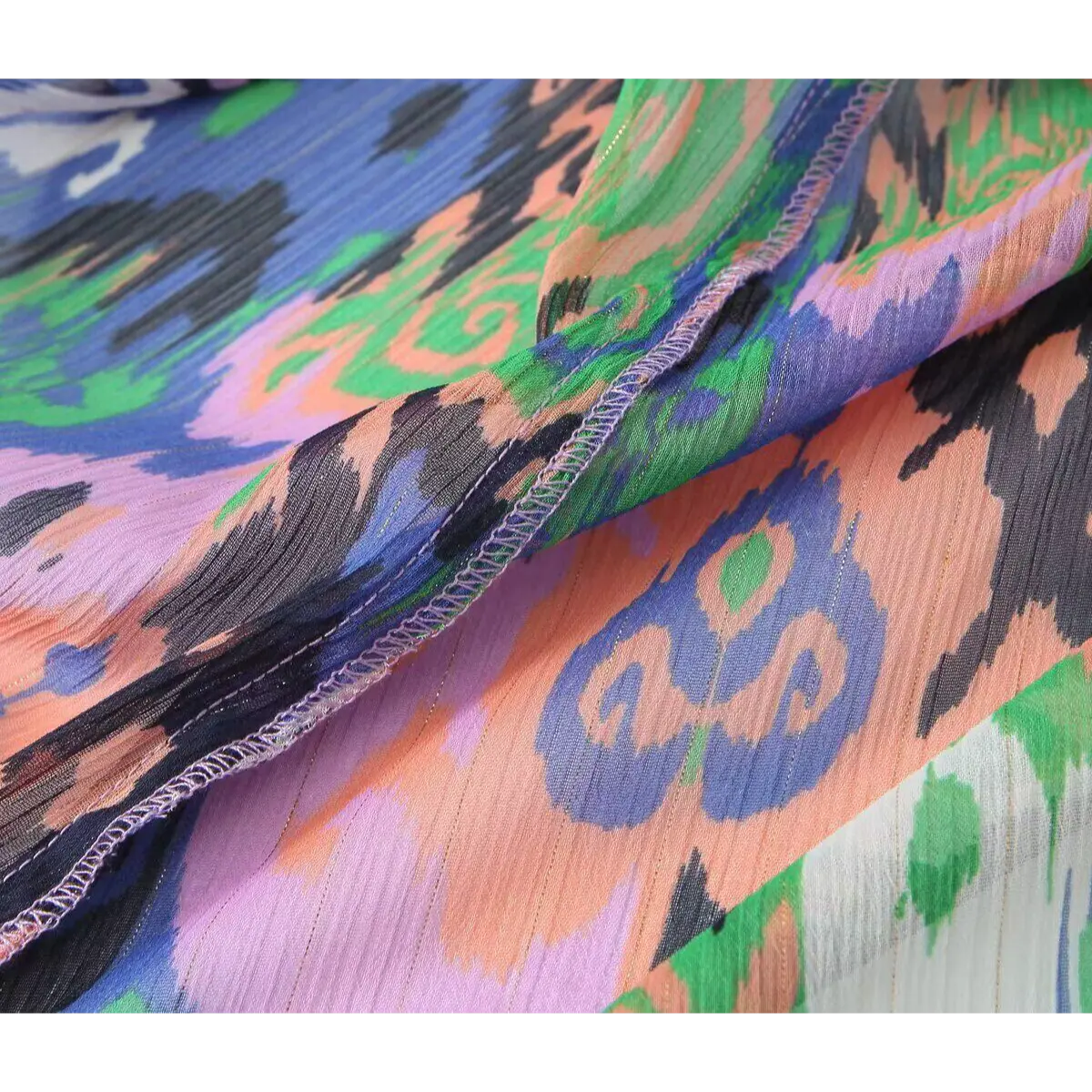 Close-up of the sheer crinkled fabric with subtle metallic threads and finished seams.