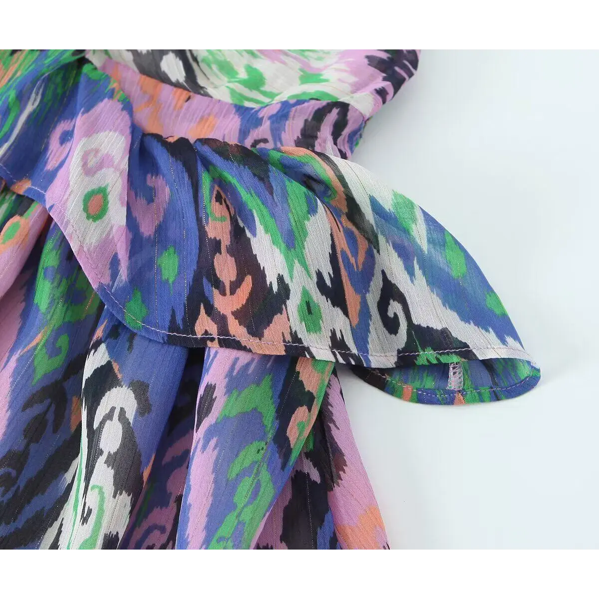 Close-up of the tiered ruffle layer on the colorful ikat print dress.