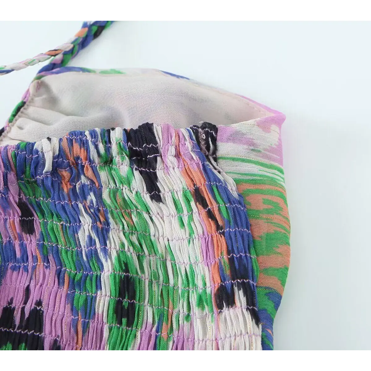 Close-up of the smocked elasticated bodice on the colorful ikat print tiered dress.