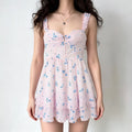 Female model wearing pink blue floral mini dress, ruffle shoulder straps, ruched bust, layered ruffle skirt, casual studio background