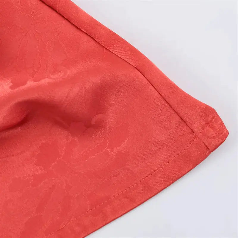 Curved relaxed bottom hem edge closeup, neat folded finished stitching on lightweight jacquard satin