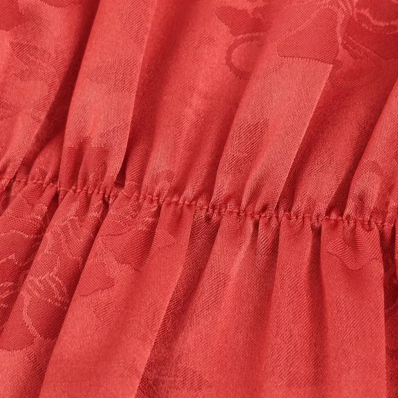 Long sleeve cuff macro shot, long fluffy coral red fringe tassel trim, matching jacquard base fabric