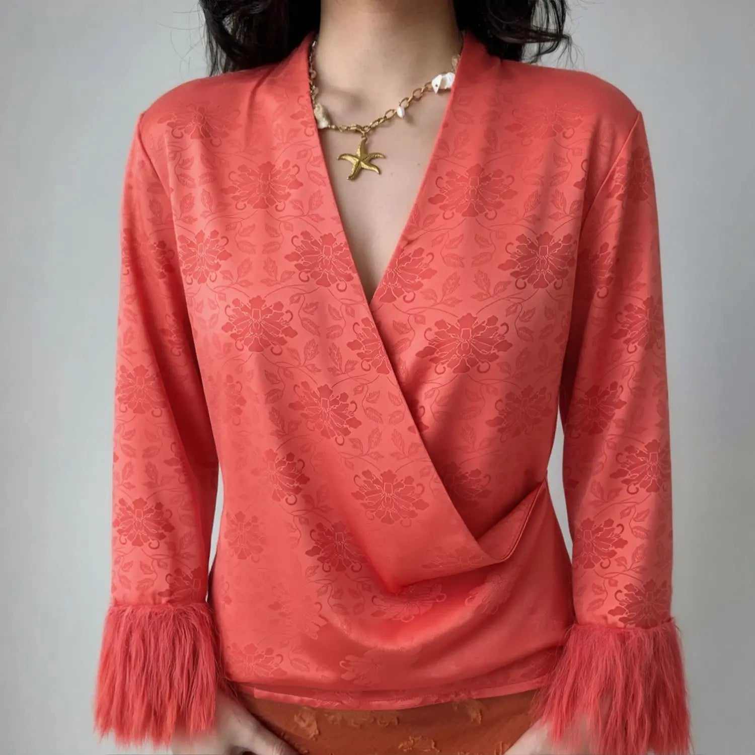 Lifestyle full model shot coral red new chinese loose layering jacket, cross surplice wrap V neck, oversized long sleeves with fluffy tassel fringe cuffs, back elastic shirred waist, match with orange midi skirt, vintage banquet daily styling