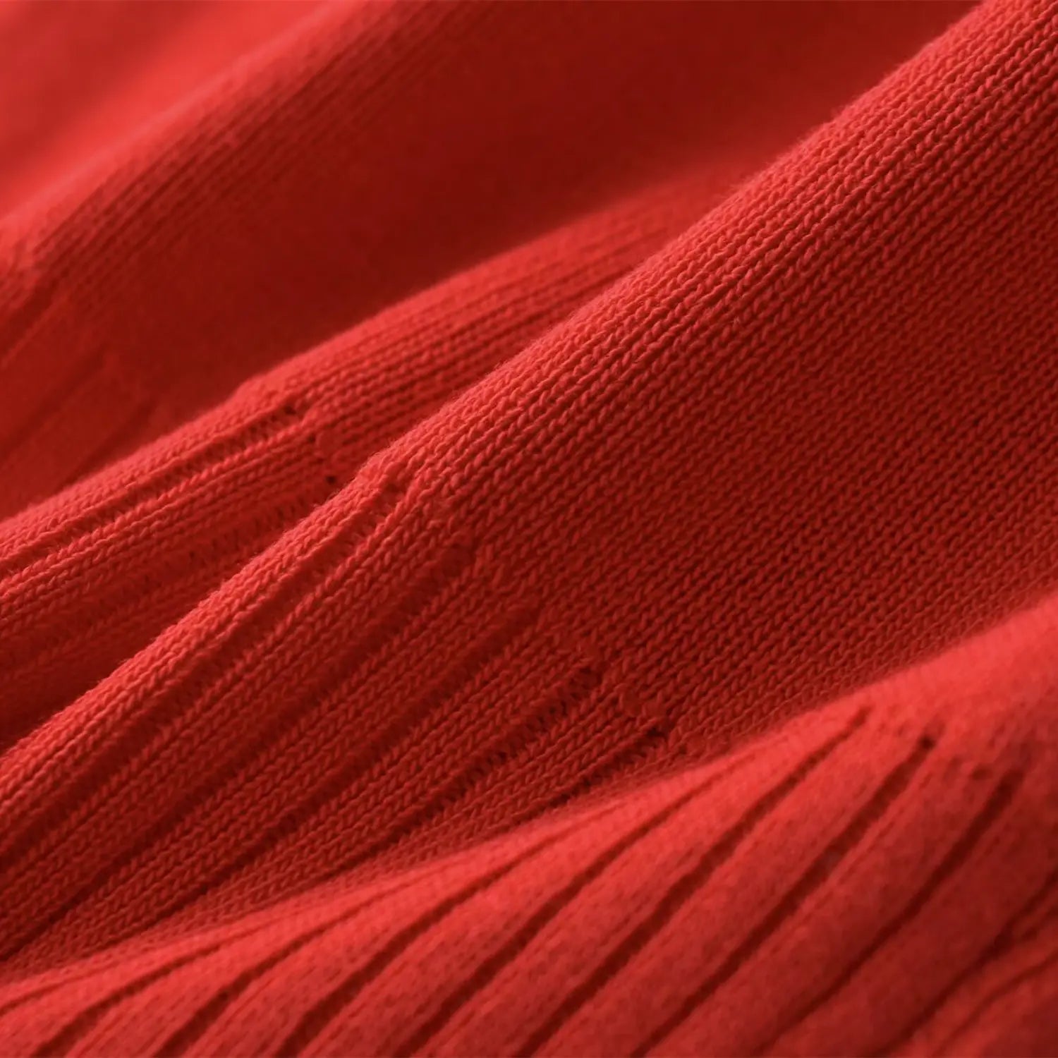 Close-up of the fine-knit texture and ribbed detailing on the coral red top