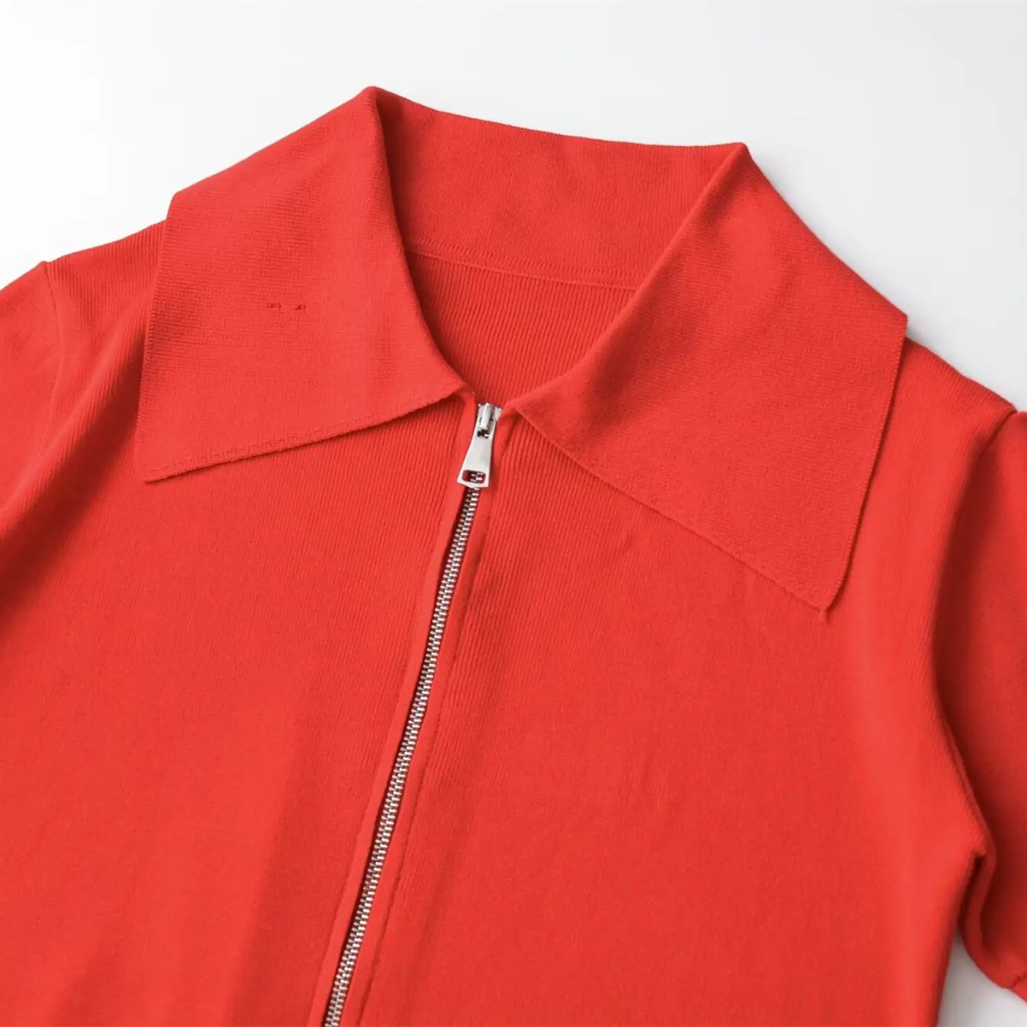 Full front view on white background of the coral red zip-up collared short sleeve knit top