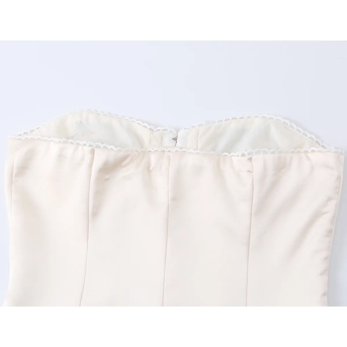 Back view of beige corset top neckline, showing delicate lace trim and inner lining detail.