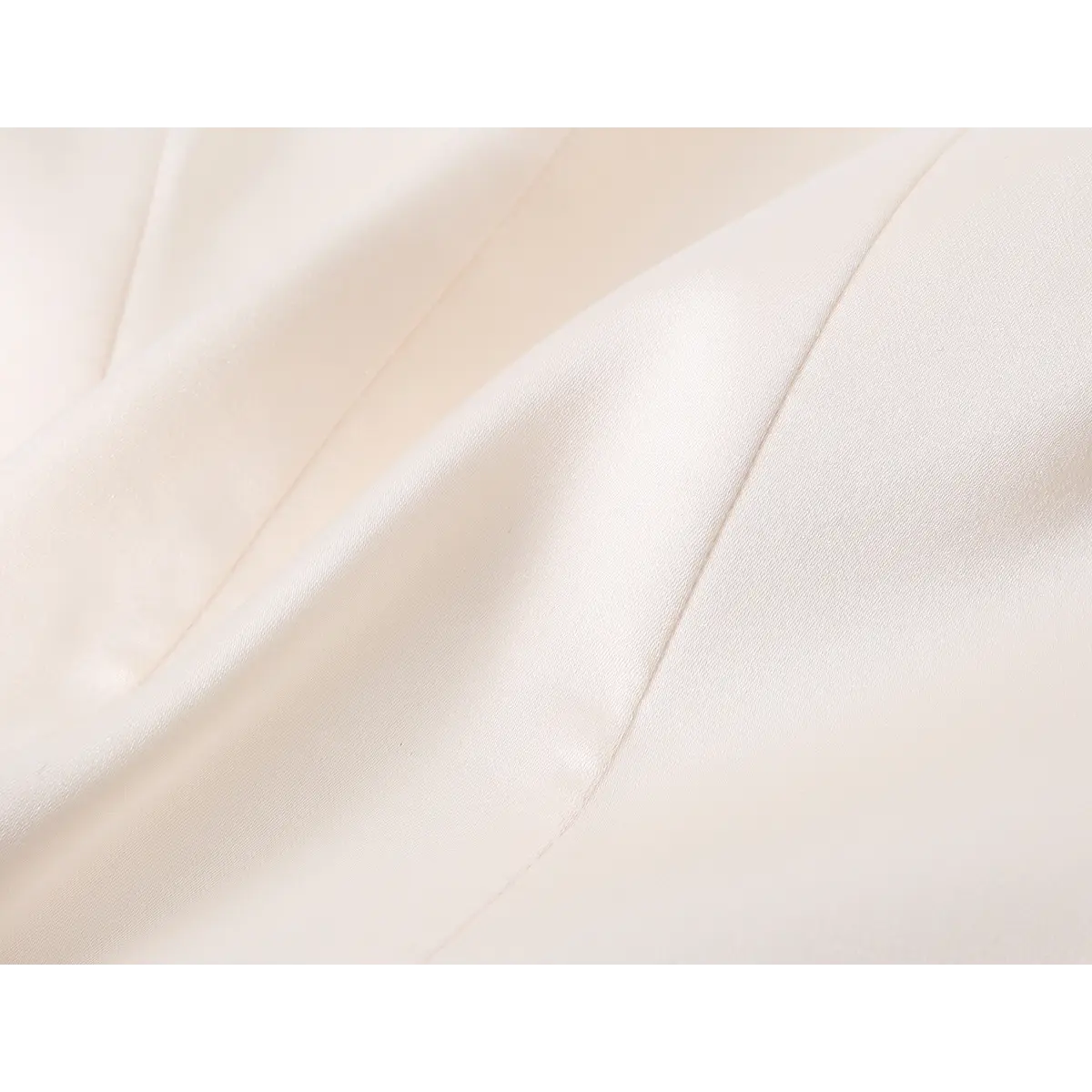 Close-up of beige satin corset fabric, showing smooth texture and fine stitching lines for a polished finish.