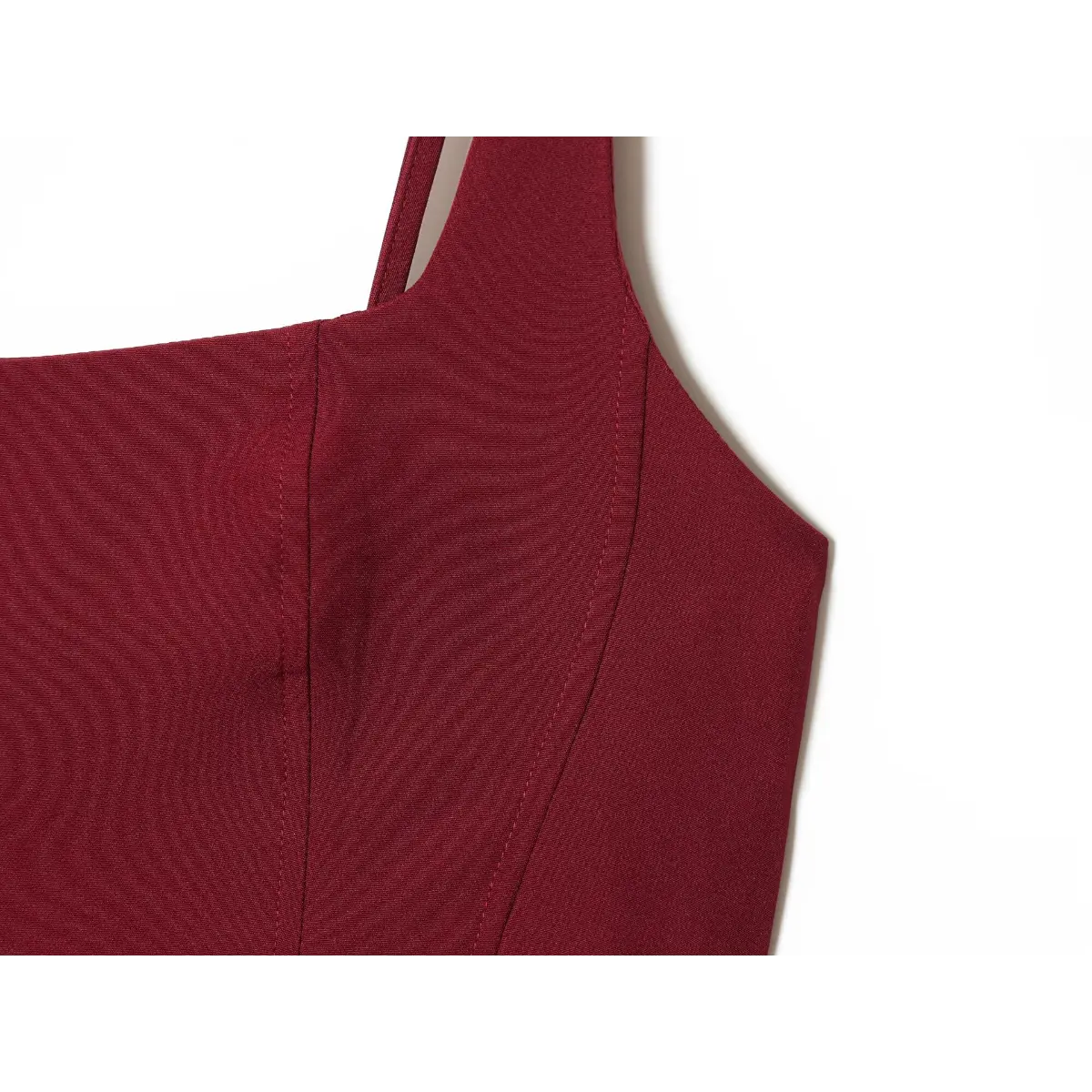 Close-up of the structured corset bodice on a wine red dress, showing the vertical stitching and seam construction.
