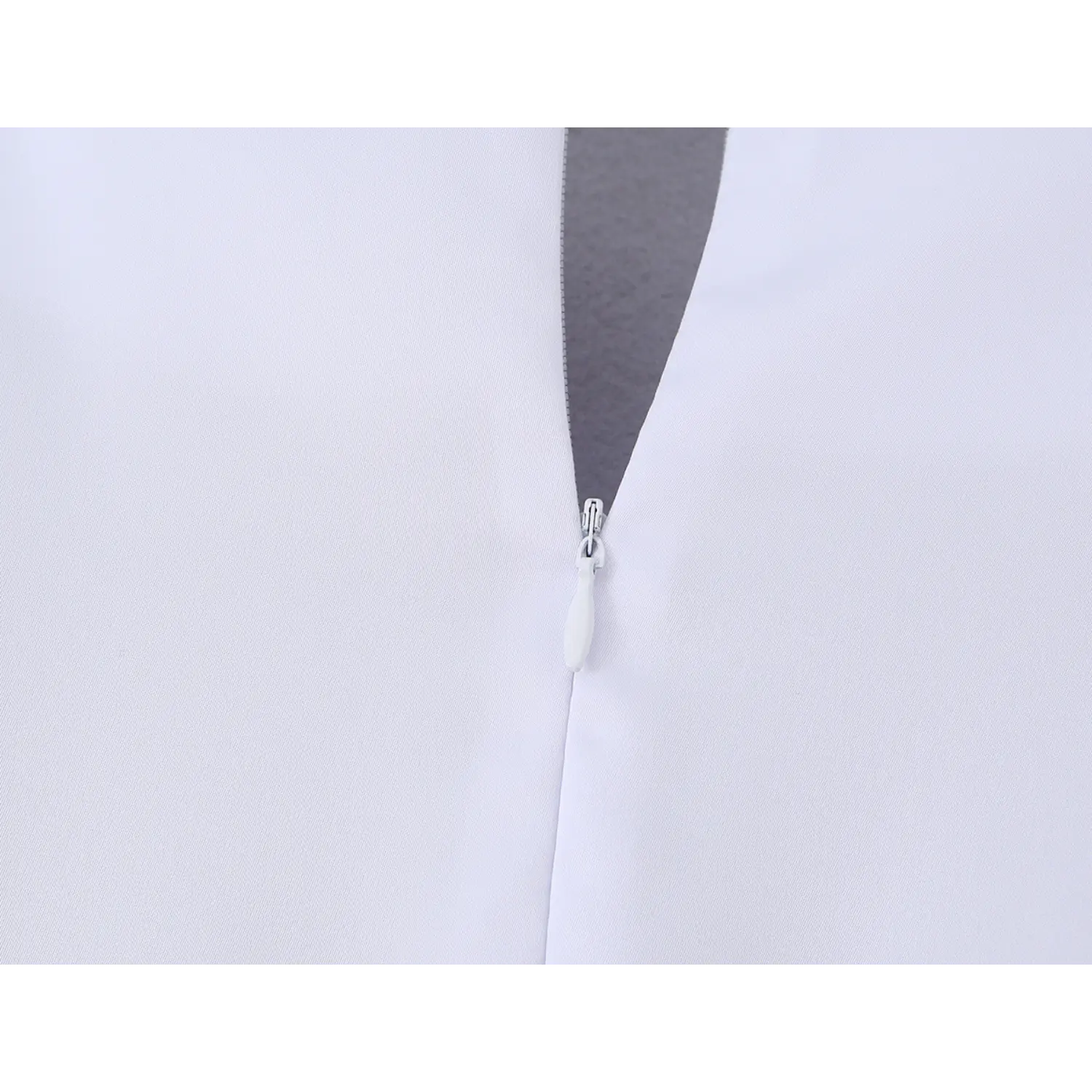 Close-up shot of invisible center back zipper on solid white midi dress, smooth fabric with fine uniform stitching along zipper placket