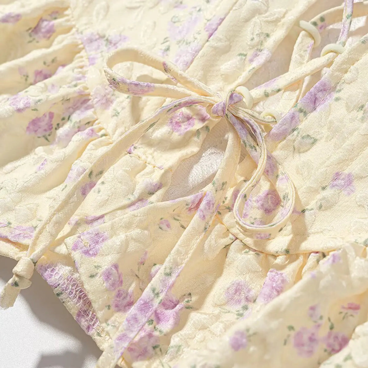 Close up of back lace-up tied knot, floral jacquard fabric for pale yellow purple corset camisole top