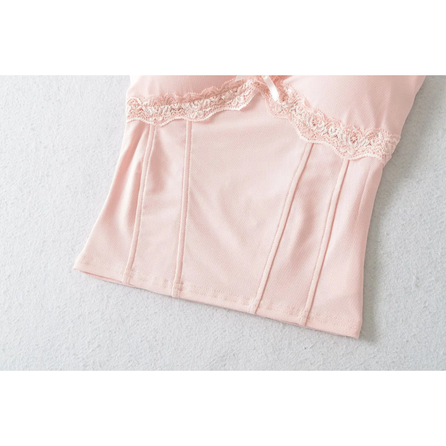 Lower torso close-up, vertical tailored stitching for waist cinching, neat hem overlock workmanship, smooth stretch mesh fabric texture