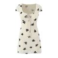 Front view cream mini dress with black floral print cap sleeve square neck lace‑up bust detail