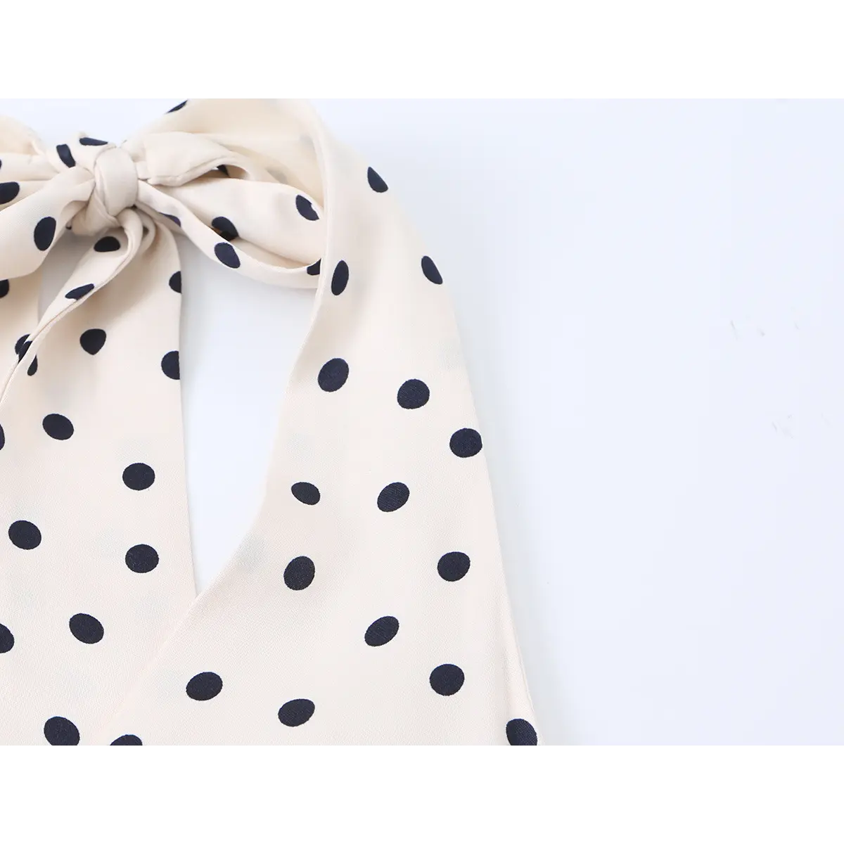 Close-up of the dress's front neckline, showing the V-shape and the halter straps.