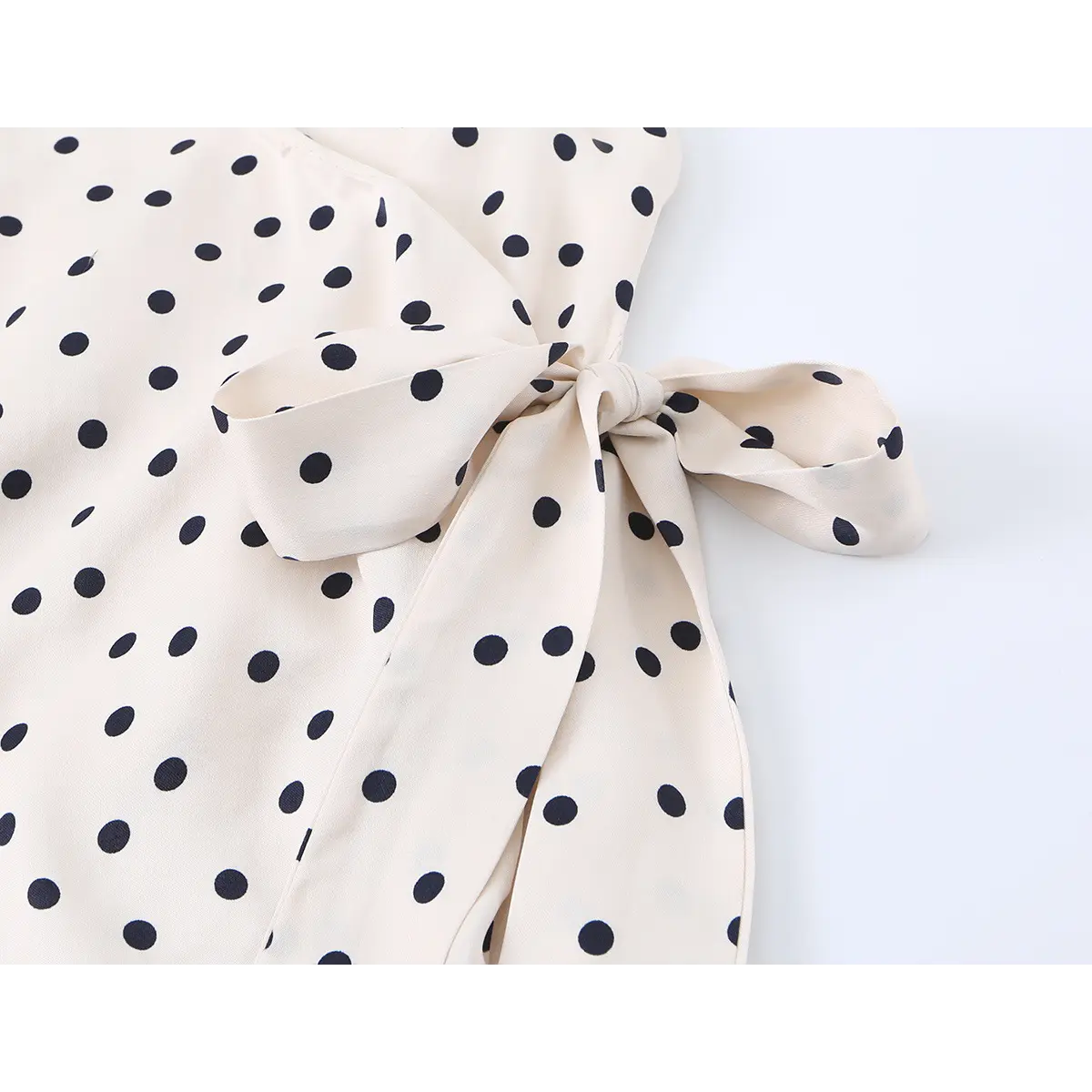Close-up of the dress's side tie, showing how the fabric is gathered at the waist.