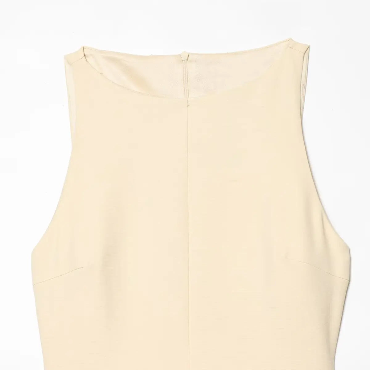 Full back view of the cream dress, showing the round neckline and center seam.