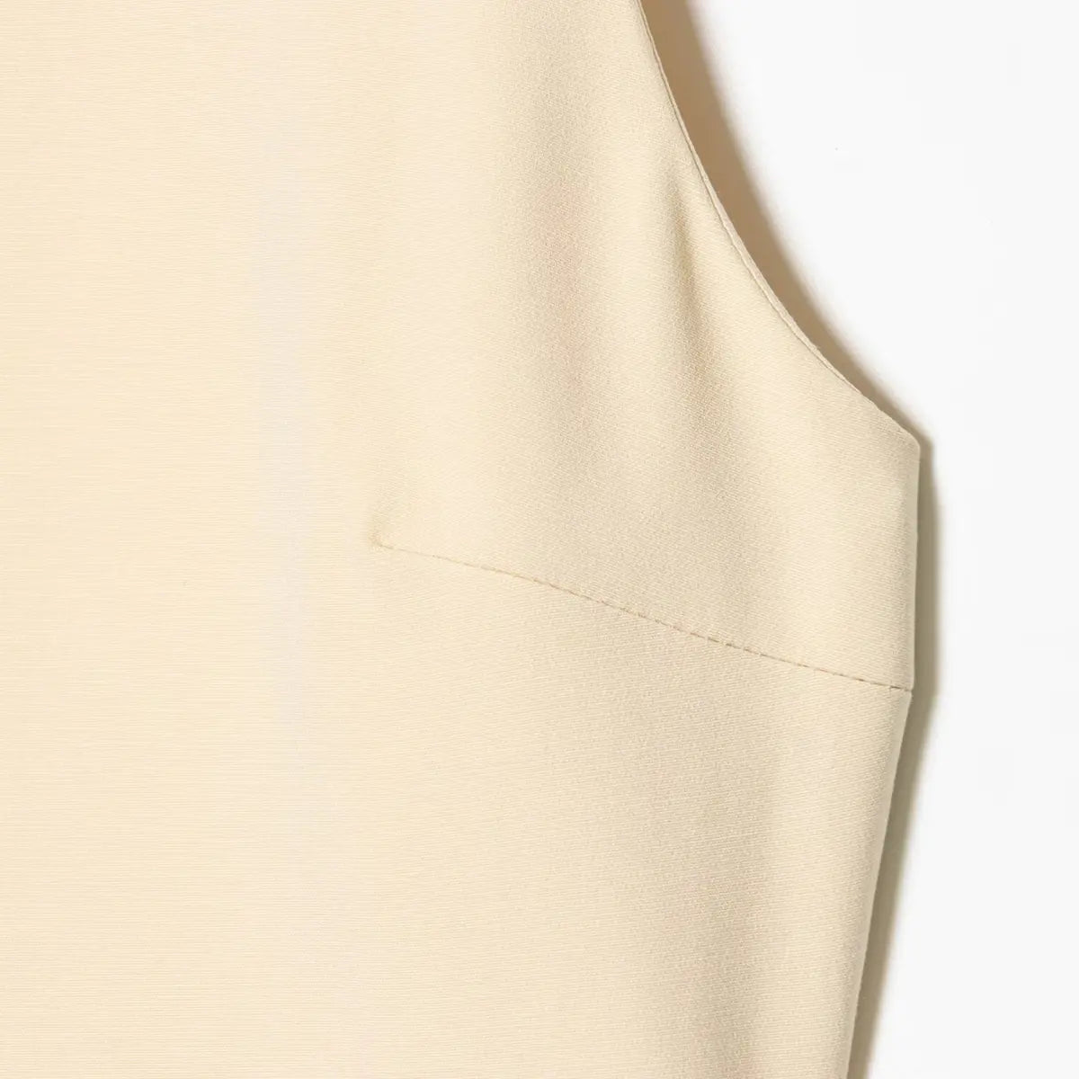 Close-up of the side seam and tailored bodice construction on the cream dress.