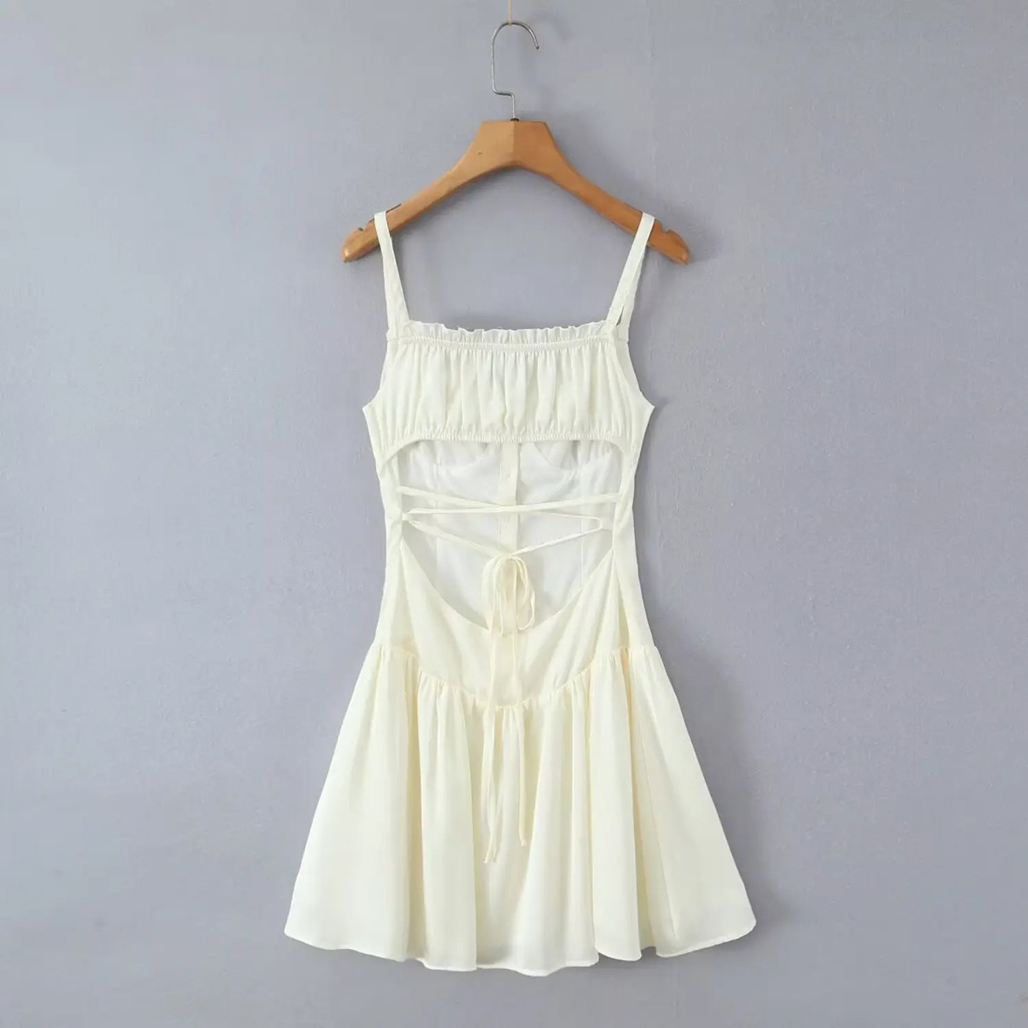 Hanging back view cream cami mini dress open back crisscross lace‑up tie wooden hanger grey wall