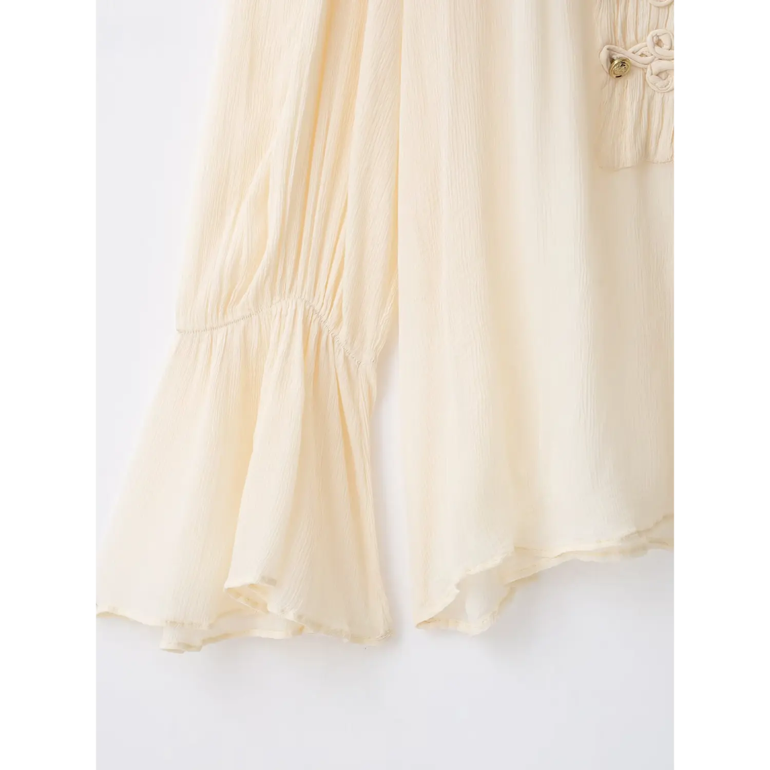 Close‑up of flared bell sleeve hem, crinkled chiffon fabric texture