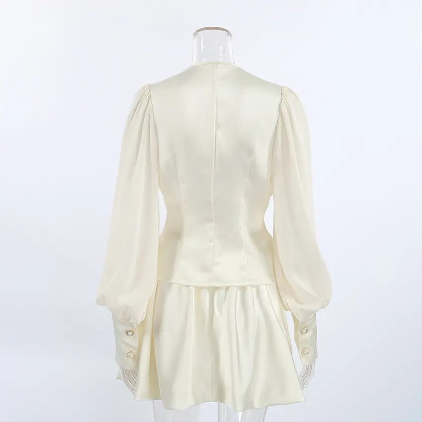 Cream chiffon bodice pearl button waist mini dress on mannequin, back view